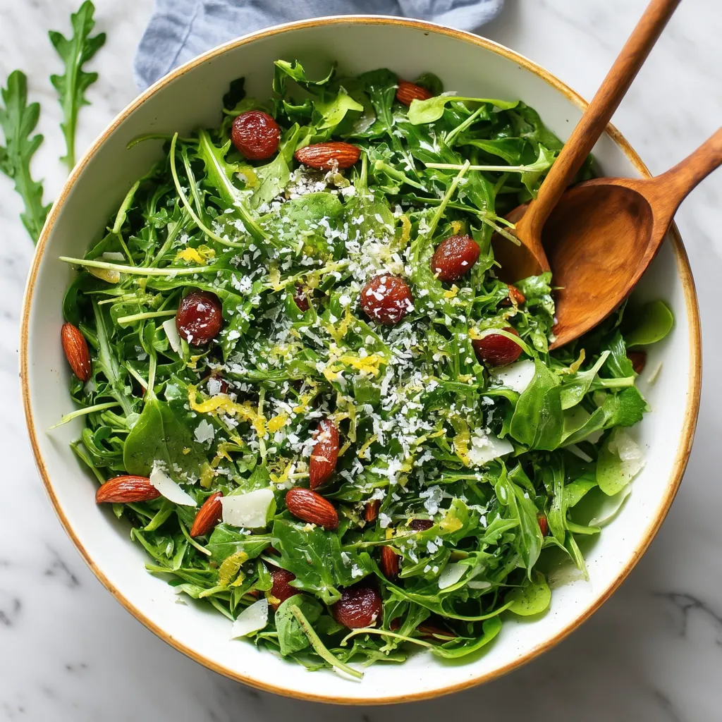 A bowl of salad with arugula, tomatoes, and lemon vinaigrette.