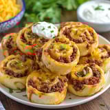 A plate of cheesy taco pinwheels.