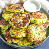 A plate of zucchini fritters with a dipping sauce.