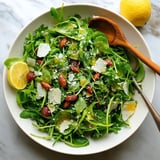 A bowl of arugula salad with lemon vinaigrette.
