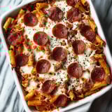 A dish of pasta with pepperoni and cheese.