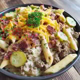 A bowl of pasta with bacon and cheese.