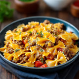 A bowl of pasta with meat and cheese.