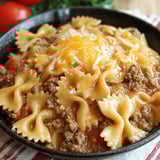 A bowl of creamy velveeta beef and bowtie pasta.