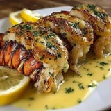 A plate of lobster tails with garlic butter and lemon.