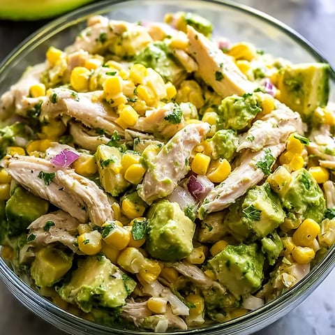 A bowl of chicken salad with avocado.